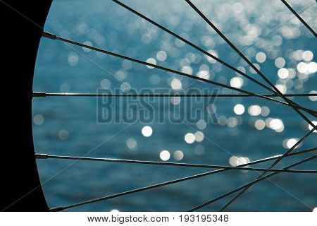 Bicycle wheel on the background of the sea. Bicycle wheel spokes