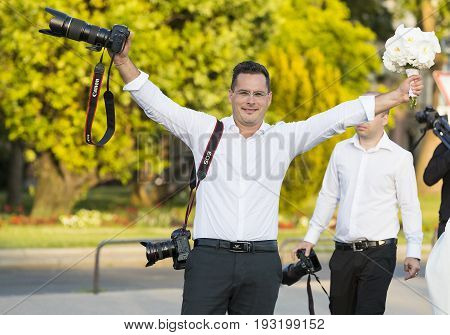 BUDAPEST, HUNGARY. 23 JUNE, 2017: A group of wedding photographers on the streets of Budapest is holding a photo session for a couple of newlyweds.