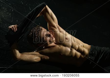 Athletic young man with naked torso taking shower studio portrait