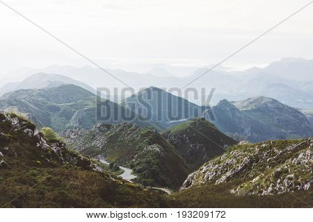 Sunset in the mountain natural landscape park. Green valley on background dramatic sky and clouds. Panorama horizon view of scenery foggy hills Northern Spain alps. Travel mockup concept in evening