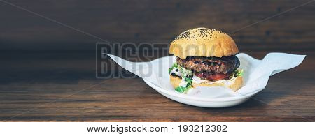 Concept fast food burger isolated american unhealthy calories meal on wood background mockup with copy space for text message or design grilled hamburger wich beef cheese tomato lettuce front view close up