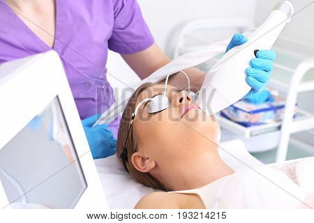 Laser hair removal from the face. Woman in the clinic of aesthetic medicine.