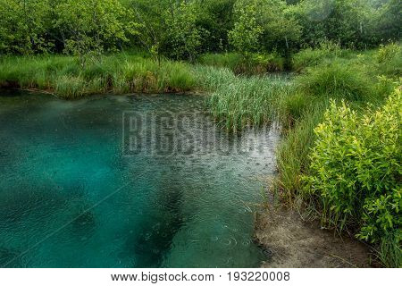 Lake during a storm. Rain pouring on Zelenci nature resort near Kransjka gora, Slovenia.