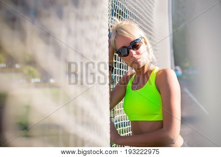 young adult sporty girl stands near the football nets