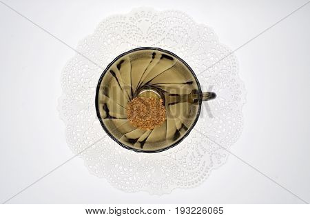 black glass small Cup on a white Lacy napkin on a white background
