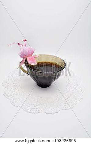 black glass small Cup on a white Lacy napkin on a white background