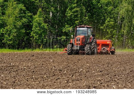 Farmer Seeding Crops On Tractor At Field. Russia