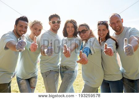 volunteering, charity, people, gesture and ecology concept - group of volunteers showing thumbs up outdoors