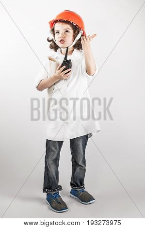 Young curly foreman explained on the radio looking up. Gray background.
