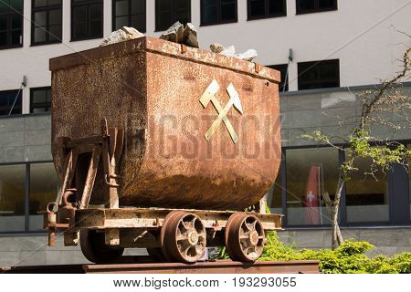 Bad Gastein Austria - JUNE 09 2017: Old mining truck in front of the Health resort Heilstollen a former mining tunnel. Near Bad Gastein Austria Europe. Hammer and pick as symbols of mining.