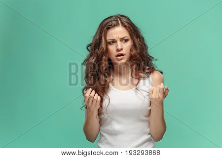 Portrait of an angry woman looking away on a blue background