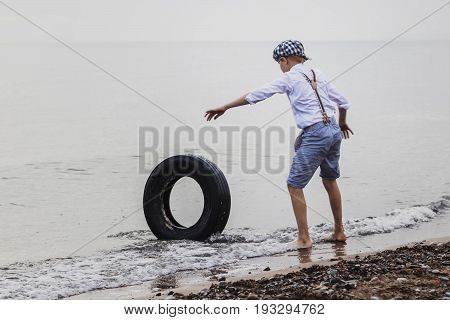 the boy at the top of an old tyre