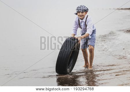 the boy at the top of an old tyre
