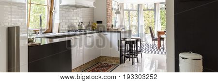 Functional small kitchen in the traditional style open to the bright dining room with large windows