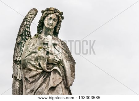 Angel with a cross. Public sculpture of angel in the cemetery.