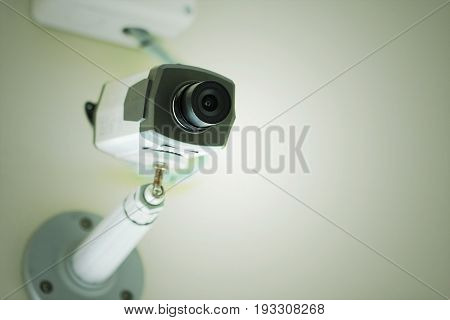 CCTV or Security camera installed on white ceiling.