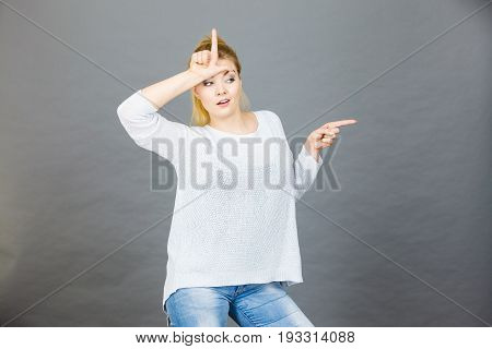 Woman Showing Loser Gesture With L On Forehead
