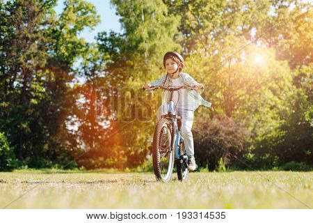 Adventurer in action. Energetic emotional passionate child enjoying his weekend and riding a bike while figuring out new routes
