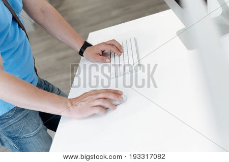 Checking before buying. Side view on an adult man standing at a display and trying out mockup template computer devices while shopping at an electronics shop.