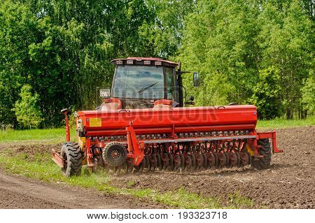 Farmer Seeding Crops On Tractor At Field. Russia