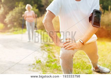 Morning workout. Close up of a nice well built aged man doing a physical exercise while having a morning workout