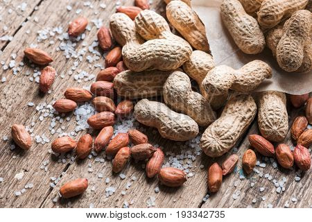 Salted peanuts are peeled and inshelled on a paper bag. Studio macro shoot