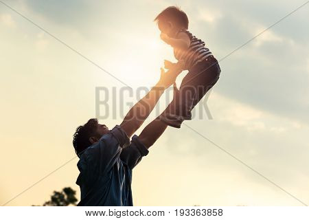 Father's day. Happy joyful father having fun throws up in the air child.
