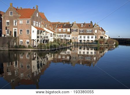 Old houses reflecting in the water in the small Dutch harbor town of Enkhuizen