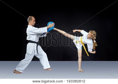 The girl beats a high kick leg on the simulator