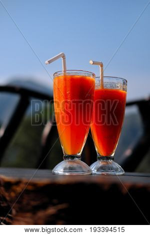 Refreshing smoothies made of papaya and mango in a glass goblet