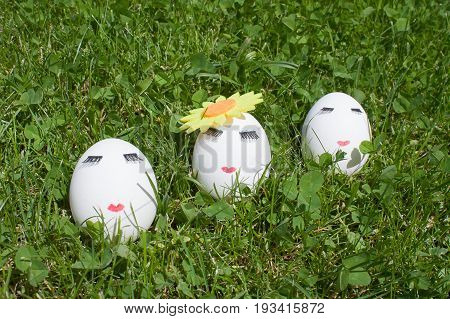 three eggs with make-up on green background