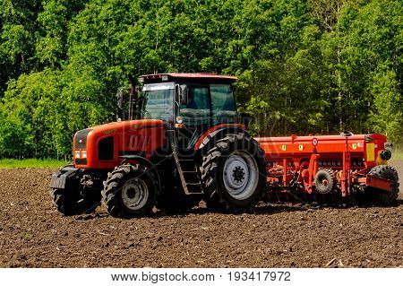 Farmer Seeding Crops On Tractor At Field. Russia