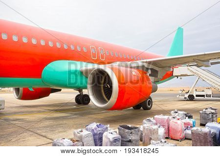 The loose luggage being loaded into narrow body aircraft at sunny day
