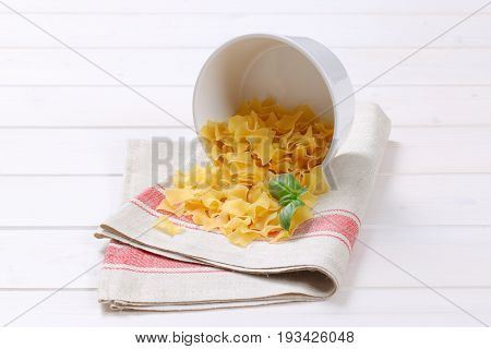 bowl of quadretti - square shaped pasta spilt out on place mat