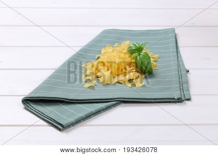 pile of quadretti - square shaped pasta on grey place mat