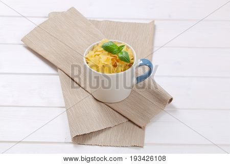 mug of quadretti - square shaped pasta on beige place mat