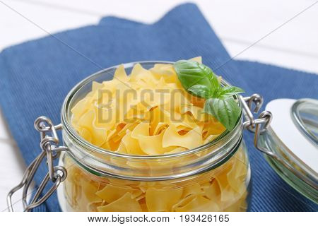 jar of quadretti - square shaped pasta on blue place mat - close up