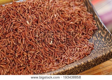 Coarse rice or half polished rice background uncooked raw cereals in wooden basket shallow depth of field.