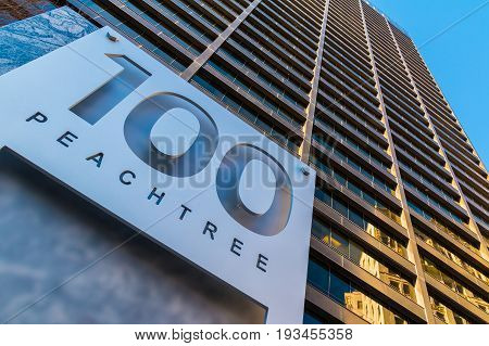 Atlanta, Georgia, USA - December 29, 2016: Bottom view of the signboard and office skyscraper at 100 Peachtree St on the background of clear sky