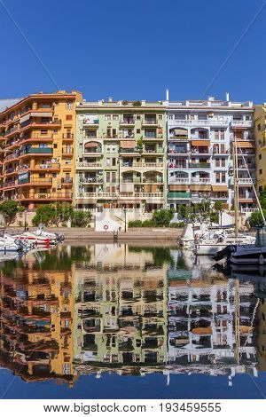 VALENCIA, SPAIN - JUNE 13, 2017: Colorful apartment buildings reflected in the water of Port Saplaya in Valencia, Spain