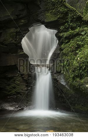 Beautiful Flowing Waterfall With Magical Fairytale Feel In Lush Green Forest Location