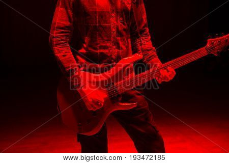 Hands Of Man Playing Electric Guitar In Red Light. Bend Technique