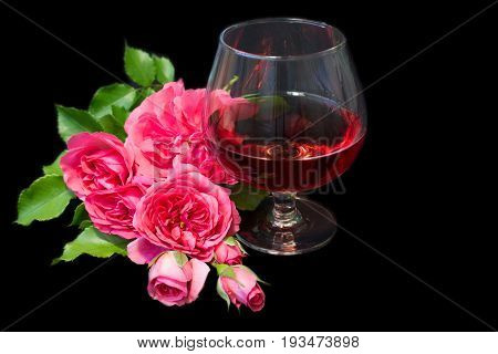 Composition with pink  wine in glases and pink roses isolated on black
