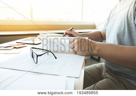 Close up of studying student hands writing in book during lecture education students college of university Reading Learning and Exam. Education concept.