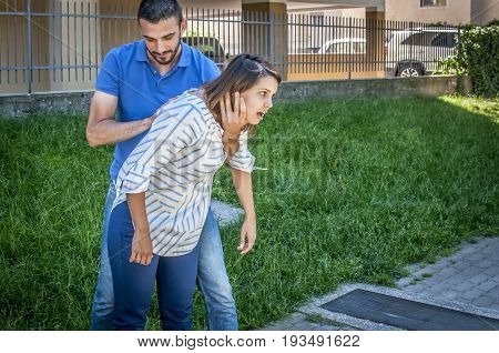 guy making the heimlich maneuver to a girl while she's chocking