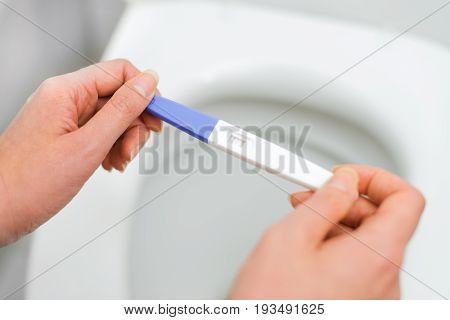 Woman Holding Positive Pregnancy Test. Close-up View.