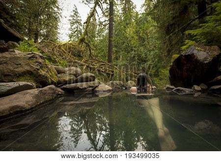 Young caucasian woman looking out from natural hot spring.