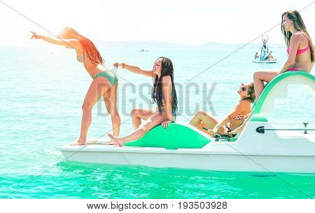 Happy friends girls having fun on rental boat on summer vacation - Cheerful young women making funny bathing jokes on pedalos sea excursion day - Playful holiday concept and teenage friendship