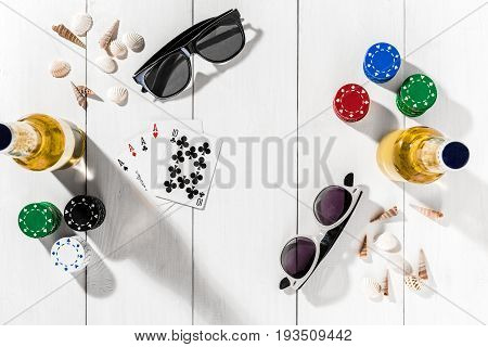 Gambling. Poker chips, cards and two bottles of beer on white wooden table. Top view. Copyspace. Poker. Summer