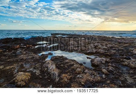 Sunset with clouds and sea waves, Crete, Greece